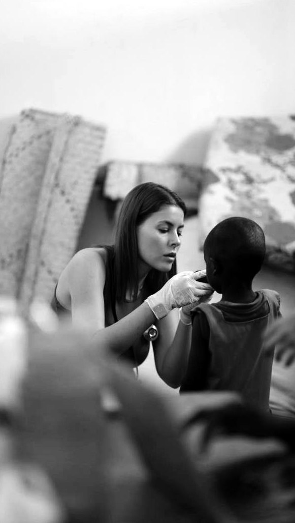 Yulia Agranovych examining a child during the medical mission in Kenya, black-and-white photograph